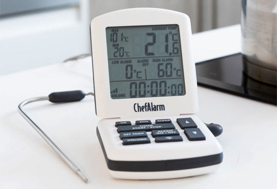 ChefAlarm digital thermometer on a kitchen counter with a probe attached.