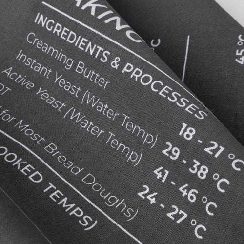 Baking ingredient and temperature chart with text on a grey tea towel
