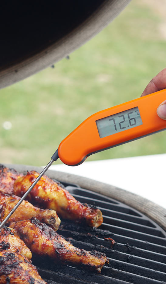 Orange Thermapen testing the temperature of chicken