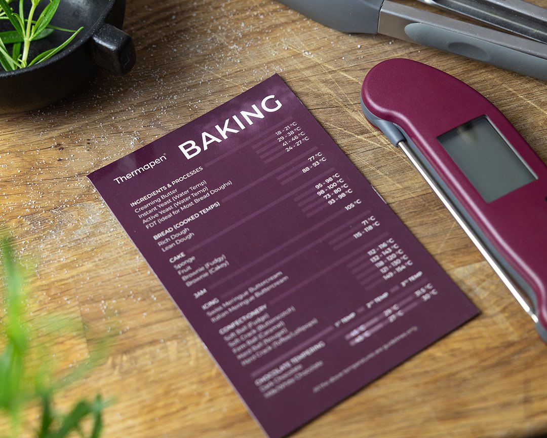 Thermapen baking magnet & Thermapen ONE raspberry on a wooden table with herbs and tongs