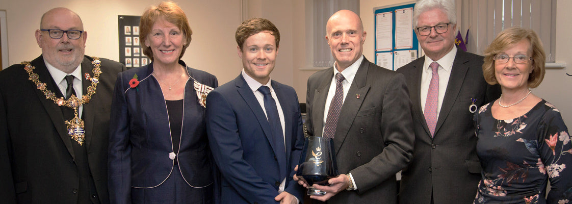 The managing director accepting and holding a 2018 Queen's Award for Innovation