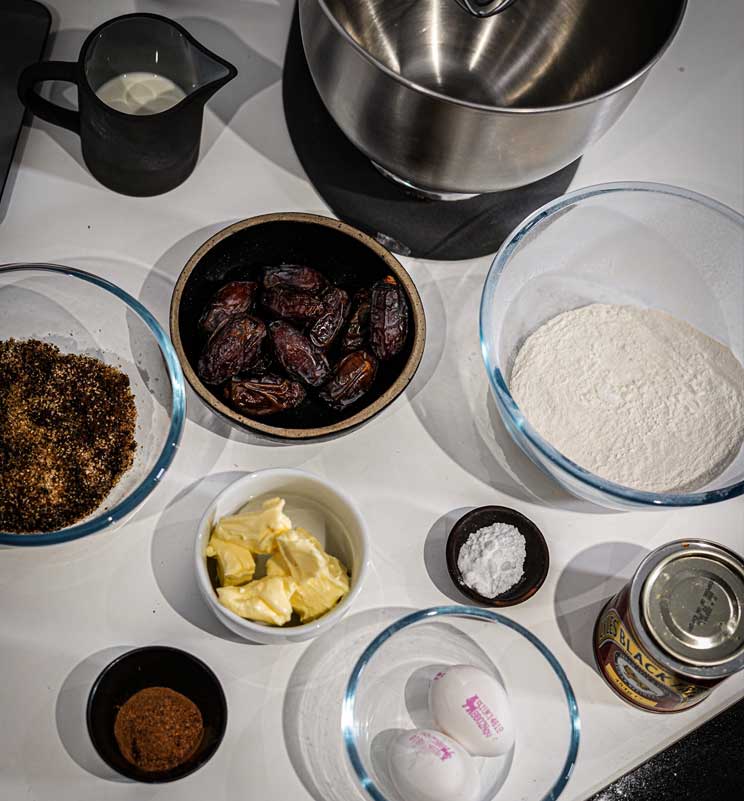 Butter, dates, dark sugar, eggs, baking powder and other sticky toffee pudding ingredients view from above