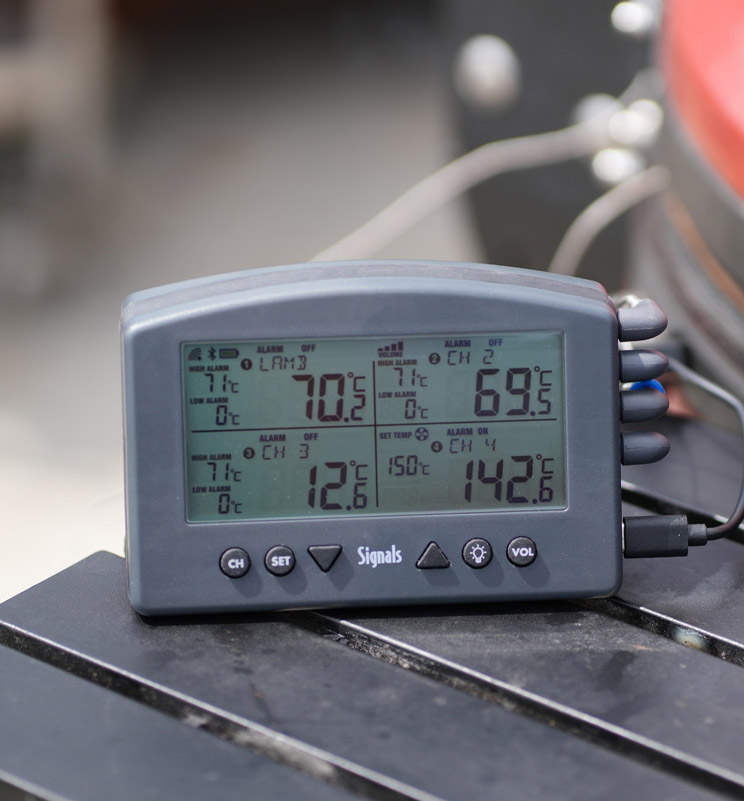 Signals thermometer sat beside a BBQ 