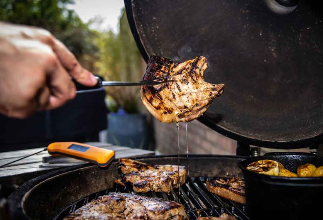 Pork chops cooked on the bbq with Thermapen Classic in the background