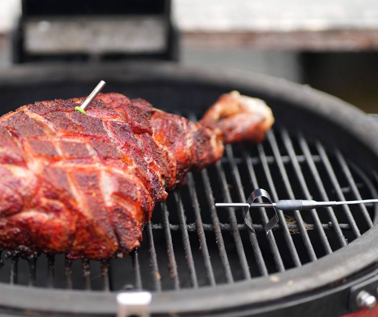 Huge lamb shoulder nicely covered in rub and scored in a diamond pattern with the RFX probe visible and the air probe attached to the grill griddle