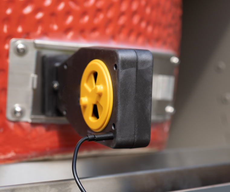 Billows BBQ Control fan attached to a Kamado styled BBQ with it's yellow fan and USB lead visible