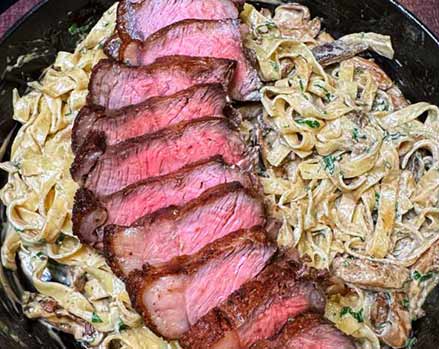 Autumnal steak pasta with sliced medium-rare steak on top of creamy mushroom fettuccine, a perfect weeknight dinner.