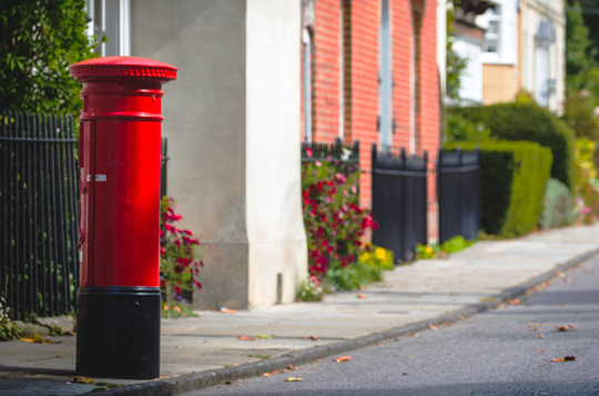 A red Royal Mail postbox on a street