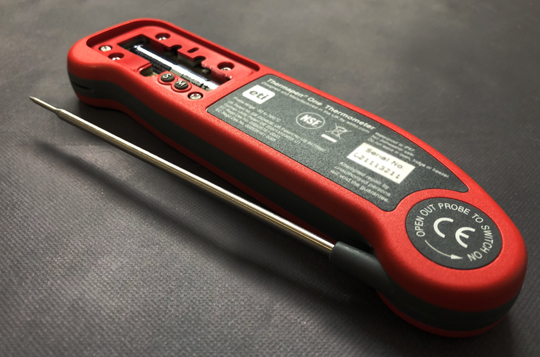 A red Thermapen food thermometer with its battery cover off 